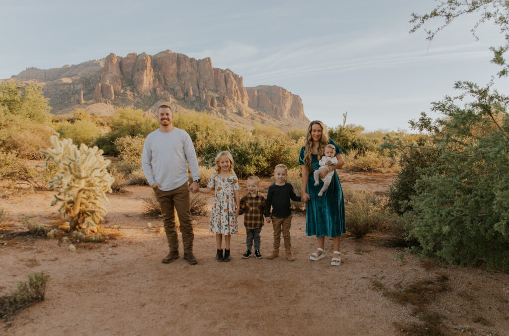 Wide angle photo of a family of six holding hands at Lost Dutchman State Park in Phoenix. #Arizonfamilyphotographer #Phoenixphotolocations #superstitionmountains #familyphotographer #ChelseyMichellePhotography #Scottsdalephotographer #familyphotosinspo #LostDutchmanStatePark