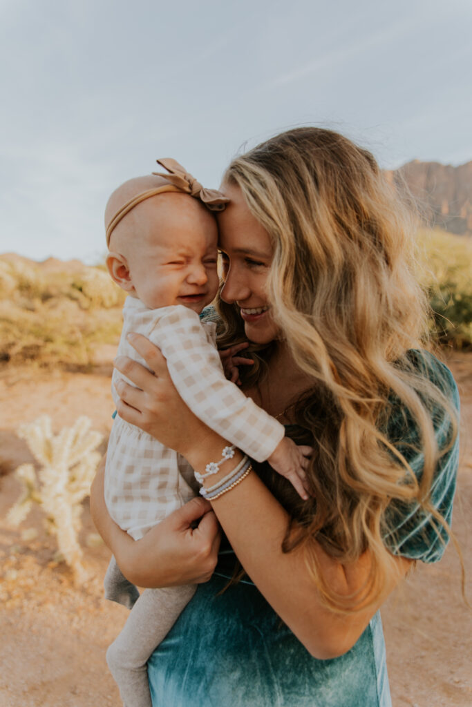 Mom and baby snuggle together in a candid moment when the little one isn’t having it during family photos. #Arizonfamilyphotographer #Phoenixphotolocations #superstitionmountains #familyphotographer #ChelseyMichellePhotography #Scottsdalephotographer #familyphotosinspo #LostDutchmanStatePark