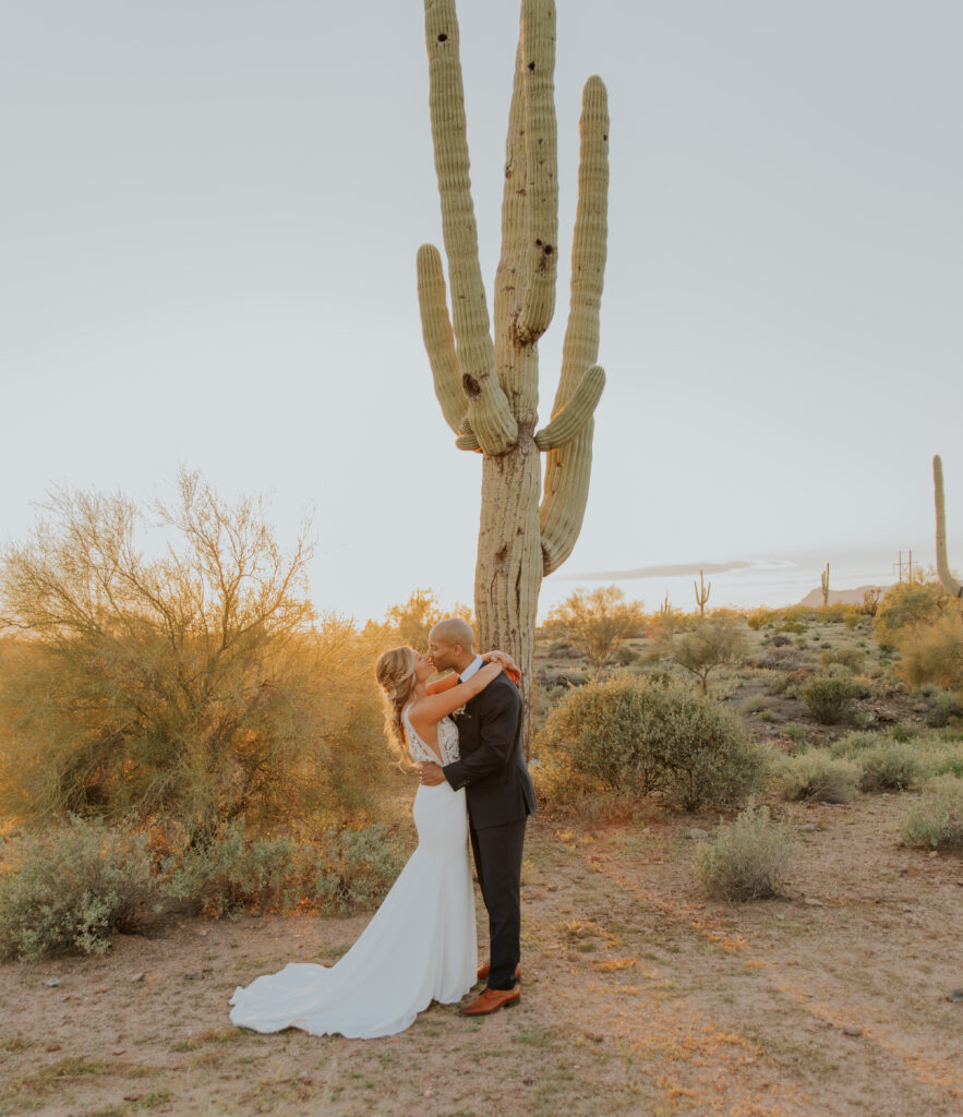 The bride and groom share a kiss at sunset in the beautiful Arizona desert outside of Phoenix. #ChelseyMichelleCoPhotography #Arizonaweddingphotographer #Phoenixweddingphotographer #Apachejunctionwedding #ThePaseo #weddingatThePaseo #Gilbertphotographer #Arizonadestinationwedding