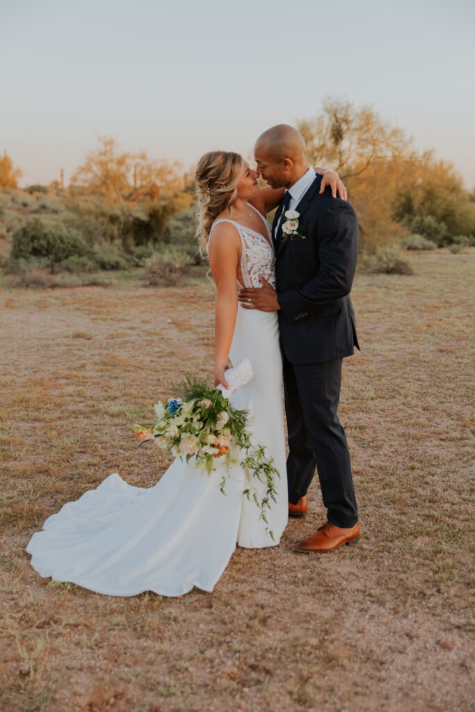 Full-length photo of the newly married bride and groom gazing at one another in the desert around Apache Junction. #ChelseyMichelleCoPhotography #Arizonaweddingphotographer #Phoenixweddingphotographer #Apachejunctionwedding #ThePaseo #weddingatThePaseo #Gilbertphotographer #Arizonadestinationwedding