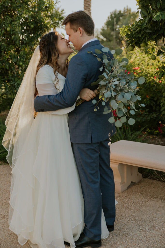 Mesa Arizona temple grounds wedding photo of bride and groom hugging during first look photoshoot. Mesa temple first look photos #ChelseyMichelleCoPhotography #Arizonaweddingphotographer #Phoenixphotographer #Mesaphotographer #Gilbertphotographer #ArizonaLDSwedding