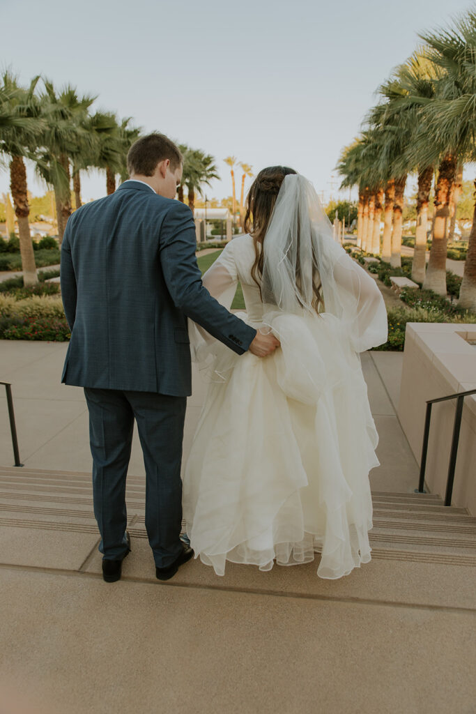 Bride and groom walking down stairs at Mesa Arizona LDS temple during first look photos. Golden hour at Mesa Arizona temple #ChelseyMichelleCoPhotography #Arizonaweddingphotographer #Phoenixphotographer #Mesaphotographer #Gilbertphotographer #ArizonaLDSwedding