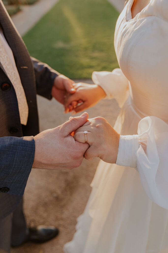 Golden hour wedding photo of couple holding hands on Mesa LDS Temple grounds. Mesa temple photo inspiration ring photo inspiration #ChelseyMichelleCoPhotography #Arizonaweddingphotographer #Phoenixphotographer #Mesaphotographer #Gilbertphotographer #ArizonaLDSwedding