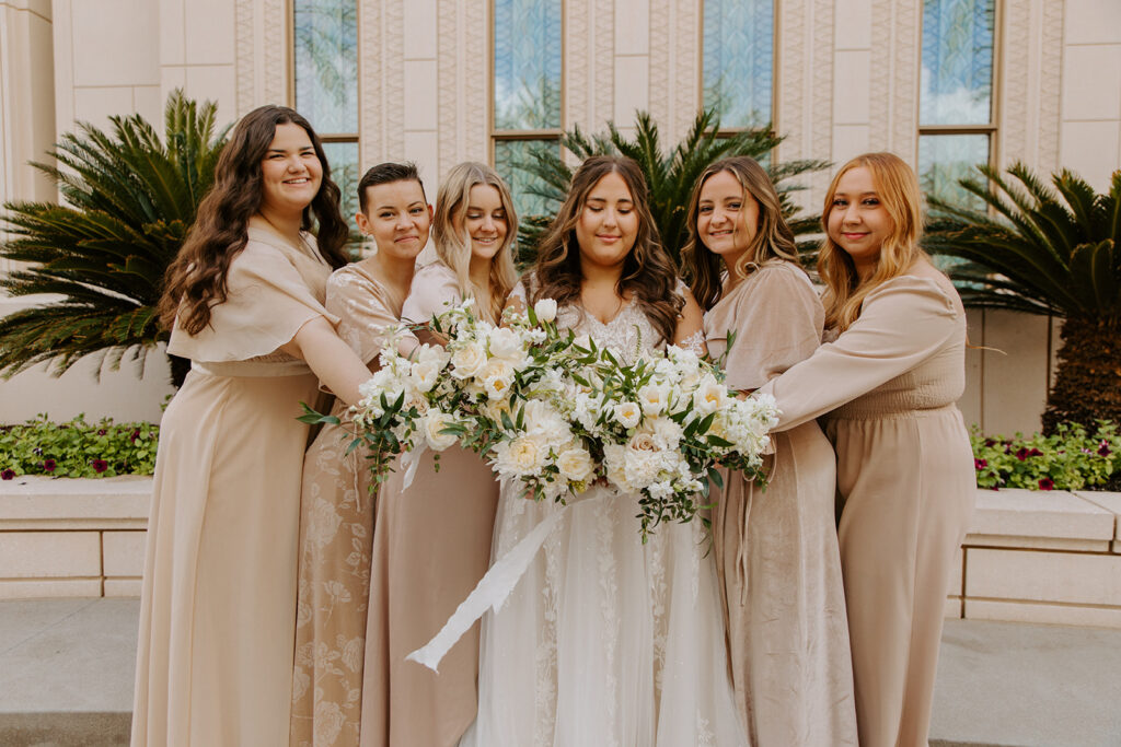 A stunning bride is pictured with her five bridesmaids dressed in beige. The focal point is all of the bouquets the women are holding with beautiful greenery and white flowers.
#ChelseyMichelleCoPhotography #Arizonaweddingphotographer #Gilbertphotographer #GilbertLDSwedding #TemplePhotographer
