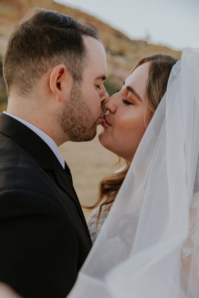 A bride and groom share a gentle kiss. Close up shot of wedding couple kissing captured by Chelsey Michelle Co Photography at Seguro Lake, Arizona. 
#ChelseyMichelleCoPhotography #ArizonaWeddingPhotographer #PhoenixPhotographer #MesaPhotographer #BridalPhotos #SaguroLake
