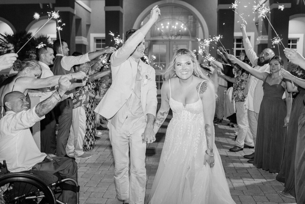 The most stunning bride walks hand in hand with her groom through a sparkler tunnel as they leave their reception. Destination wedding. Sparkler send off. #DestinationWedding #ChelseyMichelleCoPhotography #SummerWedding #FloridaWedding
