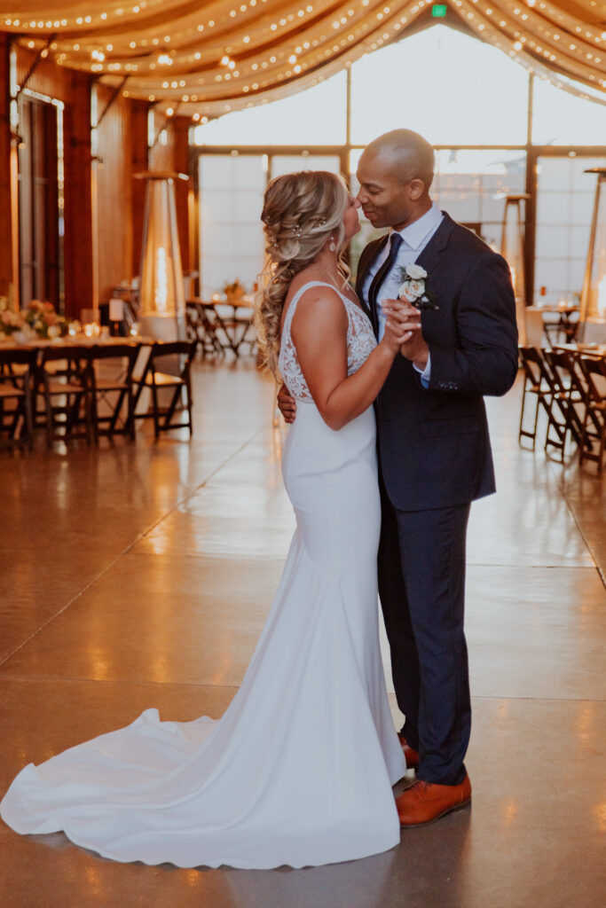 The bride and groom dance together in their perfect reception area, with every detail showcasing the day of their dreams. Indoor lighting reception venue Arizona Phoenix inspiration first dance groom suit #Desertweddingvenues #ArizonaWeddingVenue #Arizonaweddingphotographer #Mesaweddingphotographer
